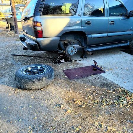 Efficient mobile mechanic servicing a van with tire removed, showcasing on-site auto repair services from AutoFordable. Contact us for reliable, affordable roadside auto maintenance.